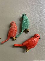 Photo shows three bird-shaped vintage Christmas light bulbs in red and green colors with screw bases.