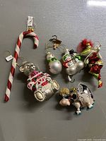 All seven ceramic Christmas ornaments displayed on a gray surface showing detail and design