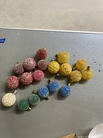 Top view showing 18 textured glass vintage holiday bulbs in various colors laid out on a surface