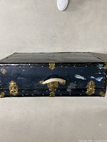 Top view of blue vintage steamer trunk with visible wear and white handle