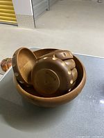 Large vintage wooden salad bowl holding smaller Baribocraft wooden bowls with circular inlay designs.