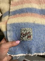 Closeup of Crathor 4HR wool label sewn into the corner of the vintage blanket, showing material and brand details.