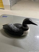 Front and side view of wooden loon decoy showing detailed paint and carving.