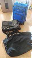Overall view of the three bags: blue rolling suitcase, khaki Samsonite bag, black Lululemon bag