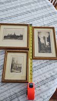 Three framed etchings with tape measure showing sizes