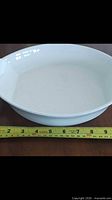 Top view of white oval dish showing interior and length tape