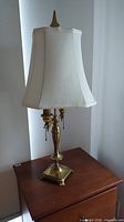 Full view of brass table lamp with shade