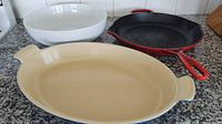 Three pieces: white bowl, red skillet, blue casserole