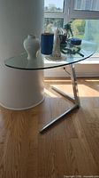 Full view of glass table showing kidney shape, chrome base and surrounding area for scale