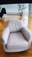 Front view of off-white leather swivel armchair