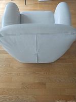 Rear view of light grey leather tub swivel chair showing stitching and shape