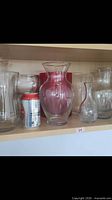 Overview of six vases on shelf with soda can for scale