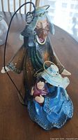 Front view of nativity figurine showing Joseph with staff and lantern, Mary with baby