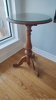 full view of round tripod end table near window