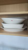 Three nested oval Sophie Conran serving bowls on shelf