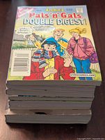 Stack of Archie comic books with visible cover of Archie’s Pals 'n' Gals Double Digest No. 92 showing characters in winter clothes.