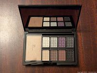 Open Doucce eyeshadow palette showing 10 eyeshadow colors and one large highlighter pan with mirror behind