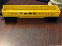 Top side view of the yellow Republic Steel model train car on a wooden surface showing the detailed printed text and logo.