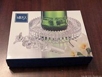 Mikasa branded box showing the diamond-patterned glass wine holder and matching stopper inside packaging, with a bottle displayed as an example on the holder.