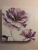 Front view of the canvas showing two large purple flowers and one small bud on a light background with a textured brushstroke style.
