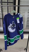 Full front view of the dark blue Vancouver Canucks jersey with number 40 and NHL logo at neckline.