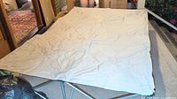 Double camping mattress raiser fully extended showing beige fabric topper and metal frame.