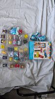 Photo showing 31 Mashems toys in capsules, Peppa Pig keychains, and boxed kids shaving kit laid out on a white cloth.