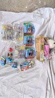 Photo showing the overall toy lot including multiple packages of Mashems, Peppa Pig keychains, Ladybug figures, and the plush dog.