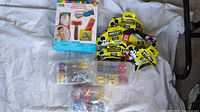 Kids shaving kit box, Mickey Mouse squishies, and Mashems in sealed plastic packs on white cloth