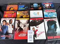 Shows 12 DVD movies arranged on a black fabric background. Titles visible for identification.