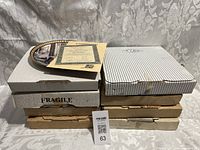 Stack of eight original boxes containing collector plates, some boxes marked fragile with wear visible