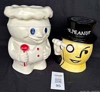 Front view showing Pillsbury Doughboy and Mr. Peanut ceramic jars with their lids and colorful detailing.