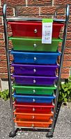 Front view of the rolling storage cart with 10 colorful drawers arranged vertically against a brick wall.
