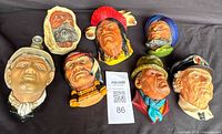 Eight vintage chalkware male heads including Native American chiefs, miner, sailor, Middle Eastern man and elderly figure.