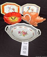 Photo showing all five vintage serving dishes with various floral and leaf designs, placed on black fabric background.