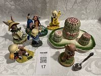 Vintage home decor lot featuring bunny figurine, GUND figurine with peacock, three ninja figurines, golf dog figurine, and asparagus salt and pepper set on a white surface.