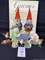 Front view of figurines arranged in front of the 'Gnomes' book showing diversity in size and color of gnomes and bunnies.