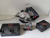 Bosch cordless circular saw with battery and two chargers (one dual bay and one single bay).