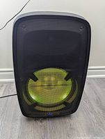Front view of the ION Bluetooth speaker with green lighting illuminated through the grille.