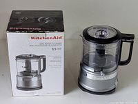 KitchenAid mini food processor with original box side by side, showing product and packaging condition.