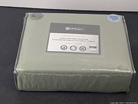 Packaged green microfiber queen size sheet set in clear plastic bag showing product label and size.