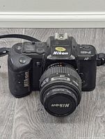 Front view of Nikon F-401 film camera body with attached lens and visible Nikon branding.