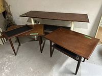 Overview of three tables: console table with white metal legs at back, two wood veneer end tables at front
