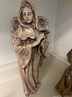 Front view of large handmade gold praying angel sculpture showing detailed face and cloak.
