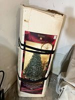 Image of boxed artificial Christmas tree labeled 'Holiday Collection' with picture of a decorated pre-lit tree on the box.