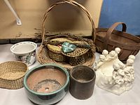 Photo of all baskets, ceramic cherubs, pottery pots, and smaller wicker pieces arranged together on a shelf or table, showing size and variety of items.