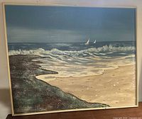 Frontal view of original oil painting depicting beach scene with waves, rocks, and sailboats.