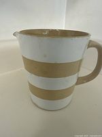 Front view of the Cornish Kitchenware measuring cup showing striped pattern and handle
