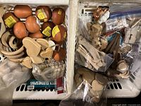 Overview of two containers filled with various wooden crafting components like spheres, rings, and small shaped pieces. Some items are packaged separately in plastic bags.