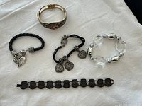 Top view of all five bracelets displayed on fabric surface